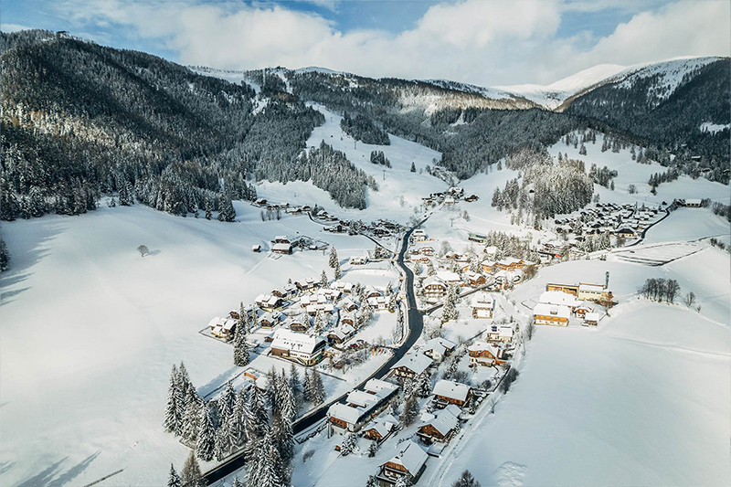 winterurlaub-kaernten-bad-kleinkirchheim Panorama Bergdorf St. Oswald im Winter mit Blick auf die Nockberge in Bad Kleinkirchheim Kärnten, ideal für Winterurlaub.